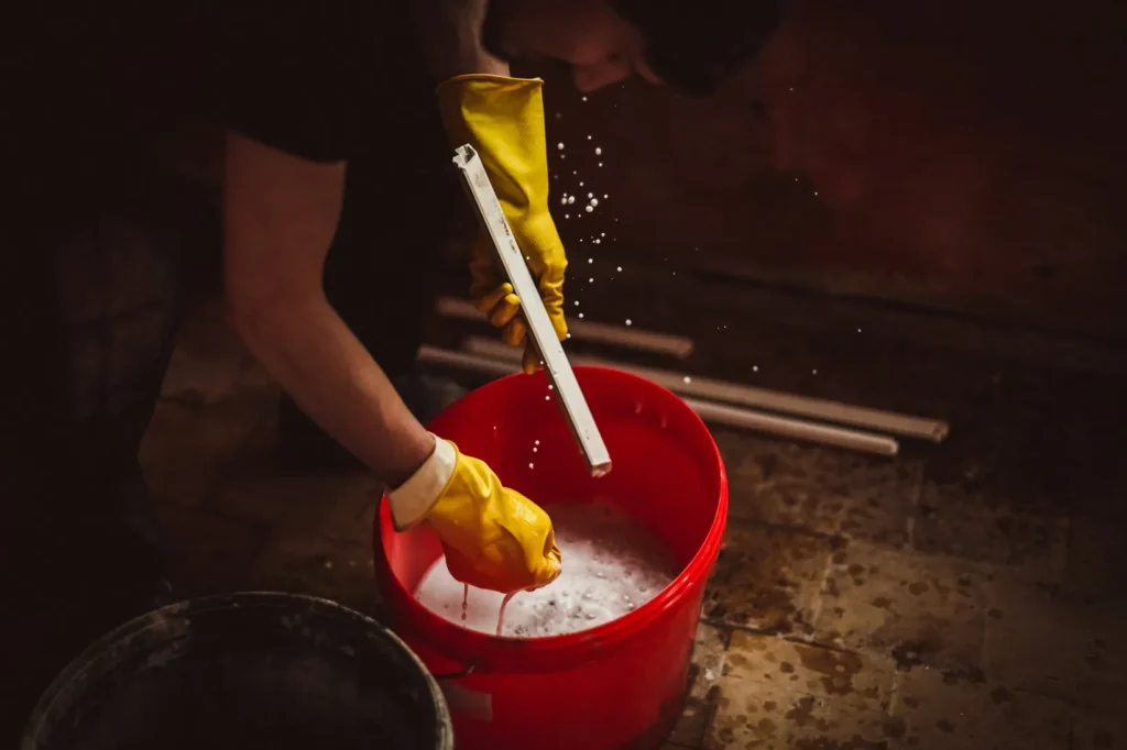Hombre listo para limpiar una industria utilizando desinfectantes industriales para garantizar higiene y control de contaminantes.